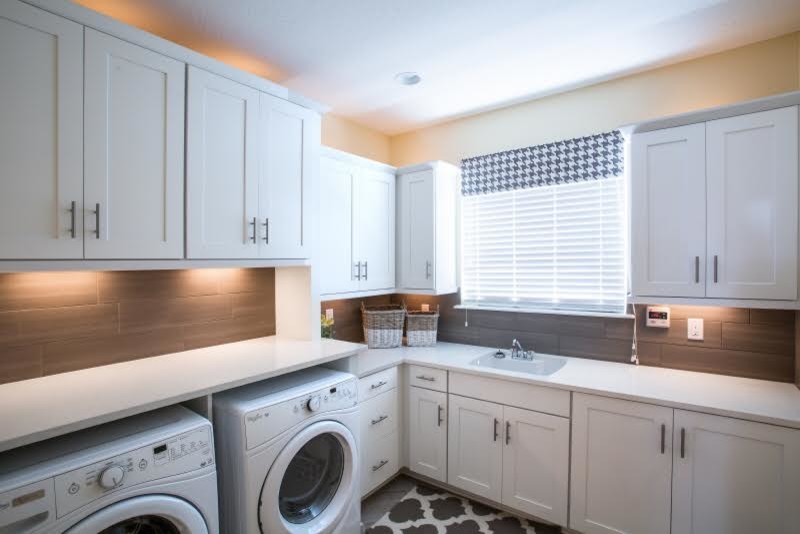 This is an example of a classic l-shaped utility room in Edmonton with a single-bowl sink, shaker cabinets, white cabinets, quartz worktops and a side by side washer and dryer.