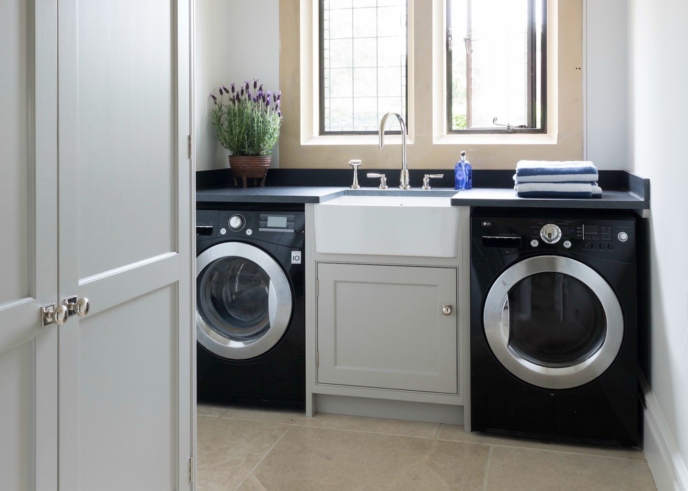 Dedicated laundry room - small modern single-wall ceramic tile and beige floor dedicated laundry room idea in Boston with a farmhouse sink, gray cabinets, soapstone countertops, gray walls, a side-by-side washer/dryer and beaded inset cabinets