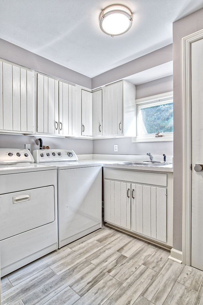 Utility room - small transitional l-shaped gray floor utility room idea in New York with a single-bowl sink, dark wood cabinets, gray walls, a side-by-side washer/dryer and white countertops