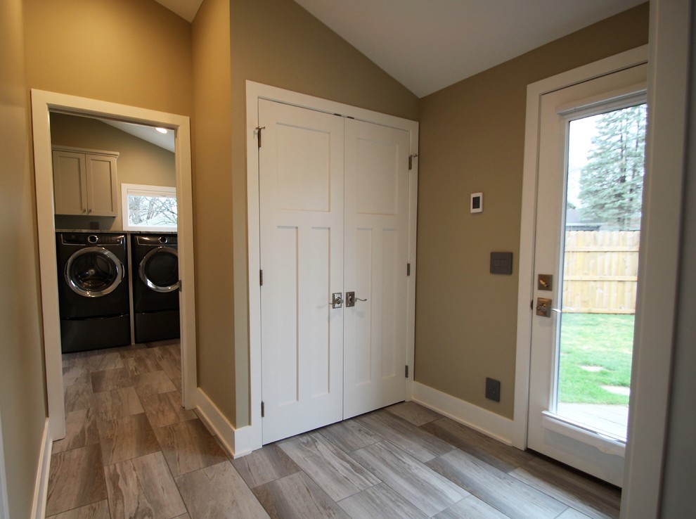 This is an example of a large traditional l-shaped separated utility room in Minneapolis with a submerged sink, shaker cabinets, white cabinets, granite worktops, porcelain flooring, a side by side washer and dryer, grey floors, beige walls and multicoloured worktops.