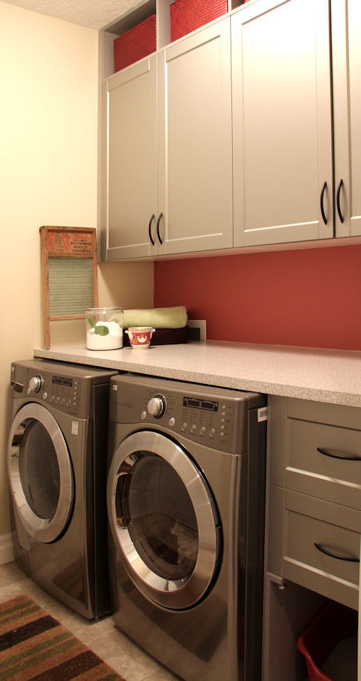 Imagen de cuarto de lavado lineal actual de tamaño medio con armarios con paneles empotrados, puertas de armario grises y lavadora y secadora juntas