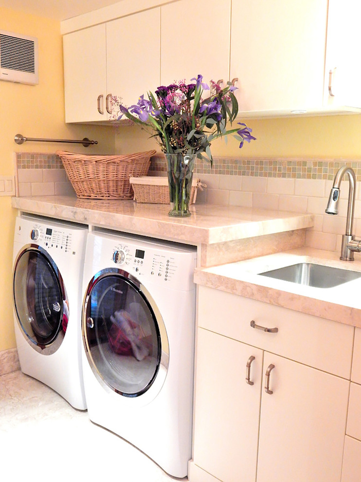 Zweizeilige, Mittelgroße Klassische Waschküche mit Unterbauwaschbecken, flächenbündigen Schrankfronten, weißen Schränken, Marmor-Arbeitsplatte, gelber Wandfarbe, Kalkstein und Waschmaschine und Trockner nebeneinander in Portland