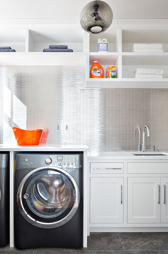 Klassischer Hauswirtschaftsraum mit weißen Schränken, Waschmaschine und Trockner nebeneinander, Unterbauwaschbecken und Schrankfronten im Shaker-Stil in New York