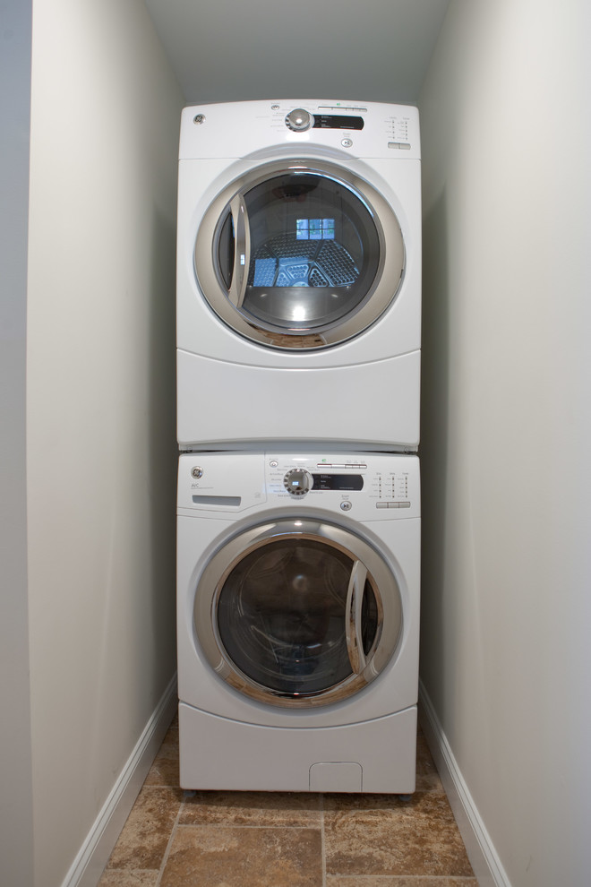 Kleiner Klassischer Hauswirtschaftsraum mit Waschmaschinenschrank und Waschmaschine und Trockner gestapelt in St. Louis