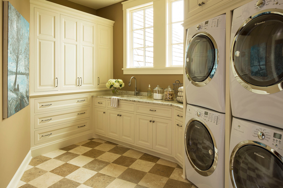 Traditional utility room in Minneapolis with a stacked washer and dryer and multi-coloured floors.