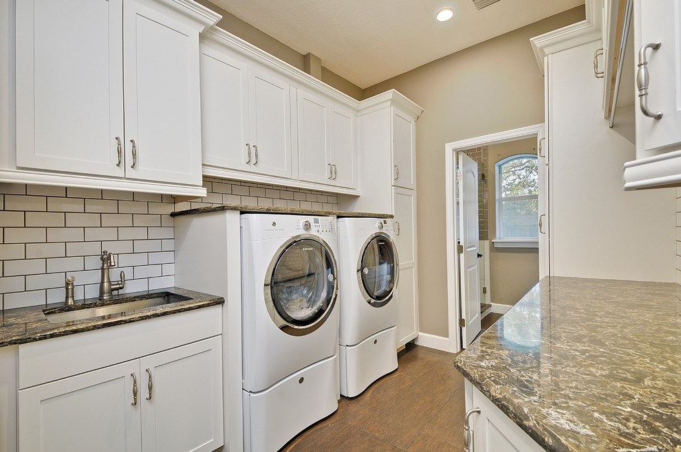 This is an example of a large traditional galley utility room in Orlando with shaker cabinets, white cabinets, engineered stone countertops, beige walls, porcelain flooring, a side by side washer and dryer and a submerged sink.
