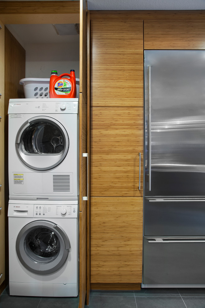 Moderner Hauswirtschaftsraum mit Waschmaschinenschrank und Waschmaschine und Trockner versteckt in Austin