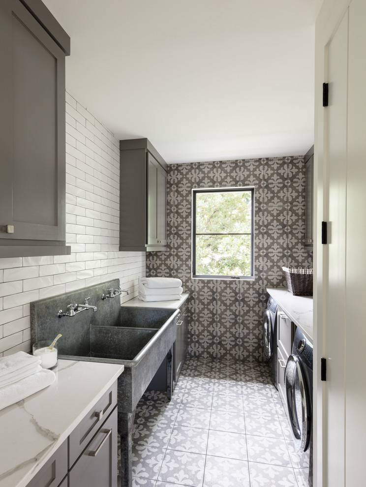 Inspiration for a farmhouse galley multicolored floor dedicated laundry room remodel in Denver with an utility sink, shaker cabinets, gray cabinets, a side-by-side washer/dryer, white countertops and gray walls
