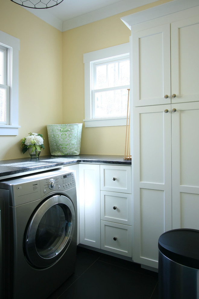 Photo of a traditional utility room in Charlotte with flat-panel cabinets, white cabinets, yellow walls and a side by side washer and dryer.