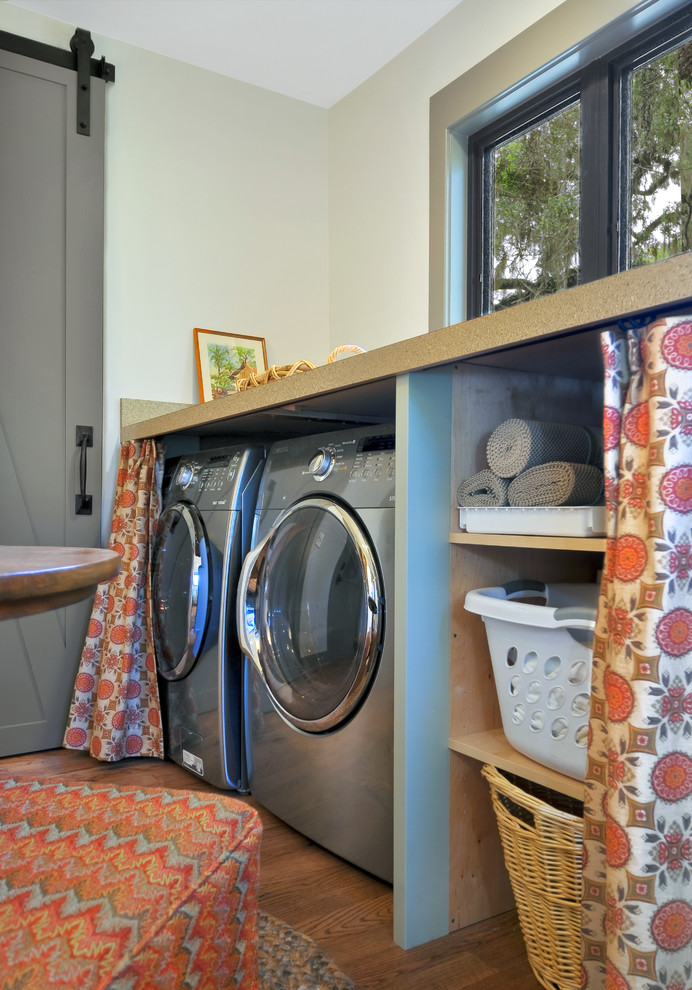 Photo of a medium sized utility room in Charleston with a side by side washer and dryer.