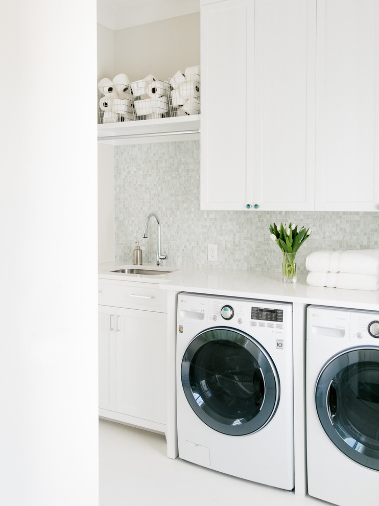 Idéer för vintage vitt tvättstugor, med en undermonterad diskho, luckor med infälld panel, vita skåp, vita väggar och en tvättmaskin och torktumlare bredvid varandra