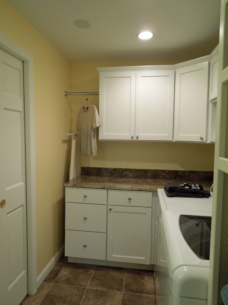 Photo of a medium sized traditional l-shaped utility room in Charleston with a submerged sink, recessed-panel cabinets, white cabinets, granite worktops, yellow walls, porcelain flooring and a side by side washer and dryer.
