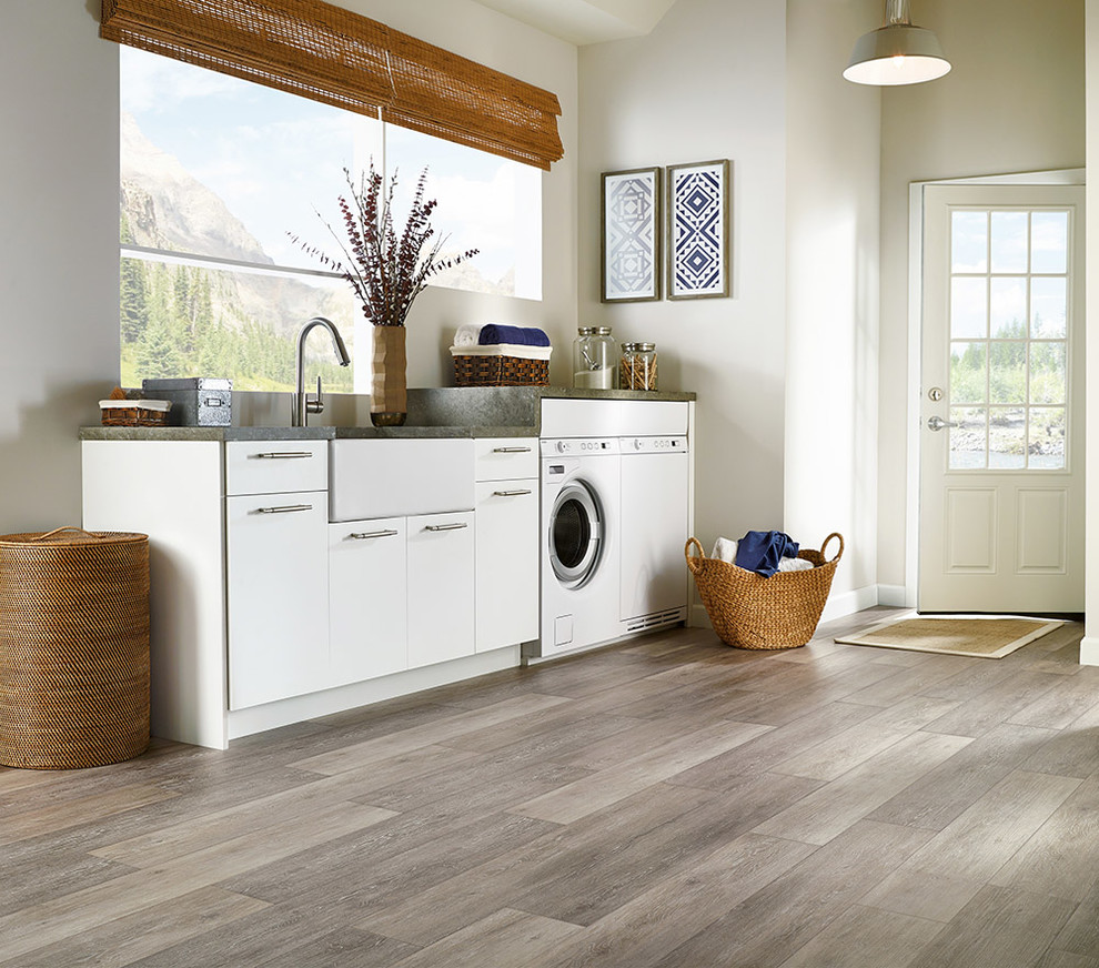 Example of an eclectic vinyl floor laundry room design in Columbus with a farmhouse sink, flat-panel cabinets, white cabinets, white walls and a side-by-side washer/dryer