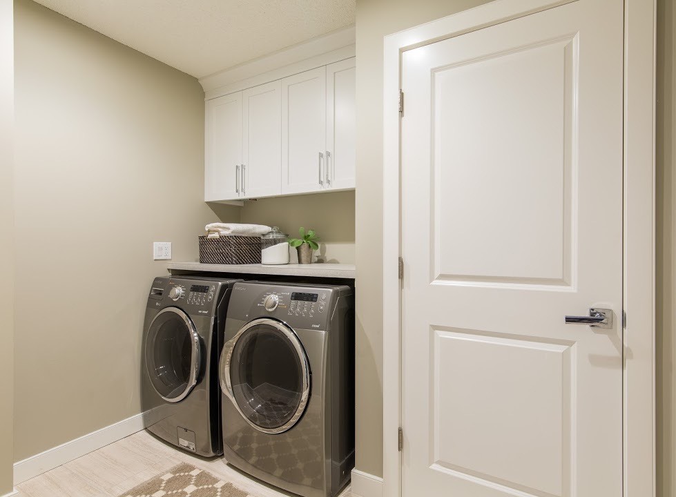 Inspiration for a small traditional single-wall separated utility room in Calgary with shaker cabinets, white cabinets, laminate countertops, grey walls, porcelain flooring and a side by side washer and dryer.