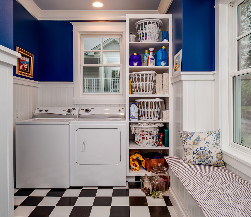 Small traditional u-shaped separated utility room in Other with open cabinets, white cabinets, blue walls, ceramic flooring, a side by side washer and dryer, a dado rail and wainscoting.