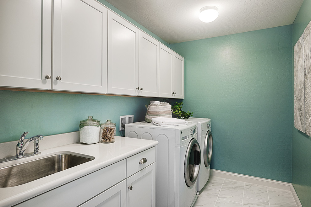 Ejemplo de lavadero contemporáneo con paredes verdes y lavadora y secadora juntas