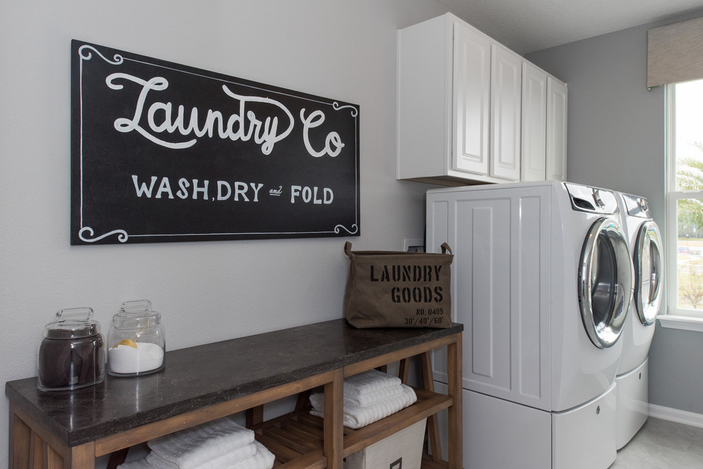 Zweizeilige, Mittelgroße Klassische Waschküche mit Schrankfronten im Shaker-Stil, weißen Schränken, Waschmaschine und Trockner nebeneinander und grauer Wandfarbe in Jacksonville