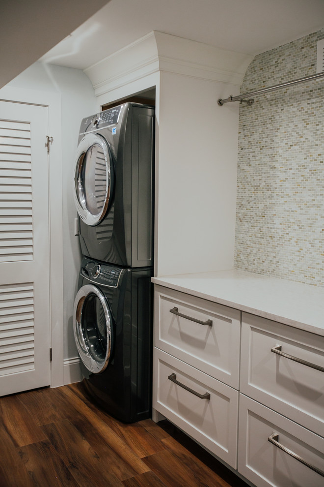 Klassisk inredning av en mycket stor vita linjär vitt tvättstuga enbart för tvätt, med en undermonterad diskho, skåp i shakerstil, vita skåp, bänkskiva i kvarts, grå väggar, vinylgolv, en tvättpelare och brunt golv