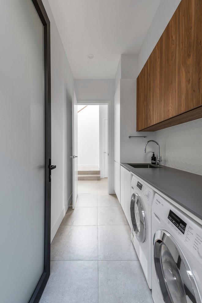 Large contemporary single-wall separated utility room in Brisbane with a side by side washer and dryer.