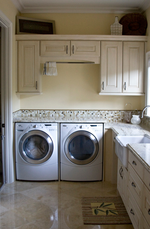Idee per una sala lavanderia classica di medie dimensioni con ante con bugna sagomata, ante bianche, top in granito e lavatrice e asciugatrice affiancate