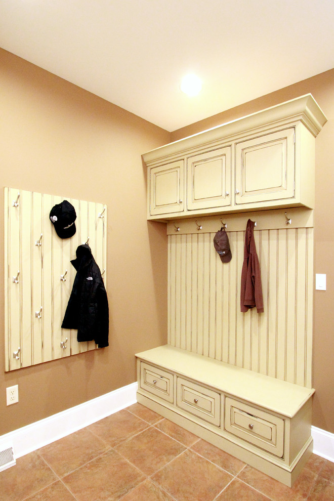 Photo of a traditional utility room in Philadelphia with beaded cabinets, distressed cabinets, wood worktops, brown walls and porcelain flooring.