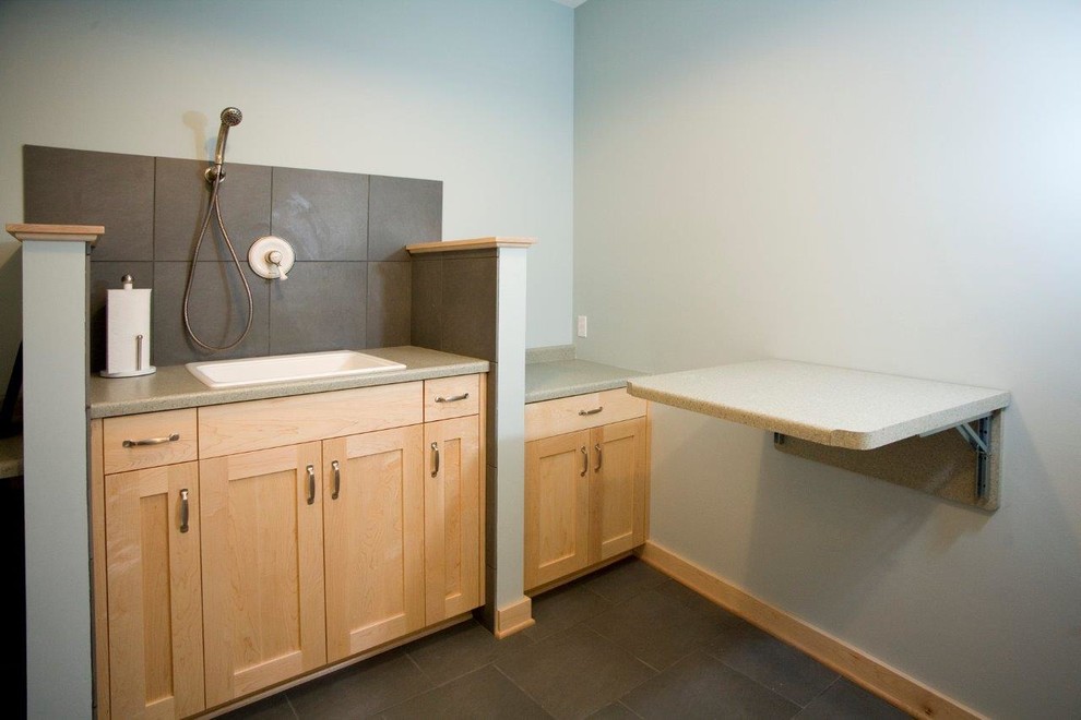 This is an example of a classic l-shaped utility room in Minneapolis with a built-in sink, flat-panel cabinets, light wood cabinets, laminate countertops, grey walls, porcelain flooring and a side by side washer and dryer.