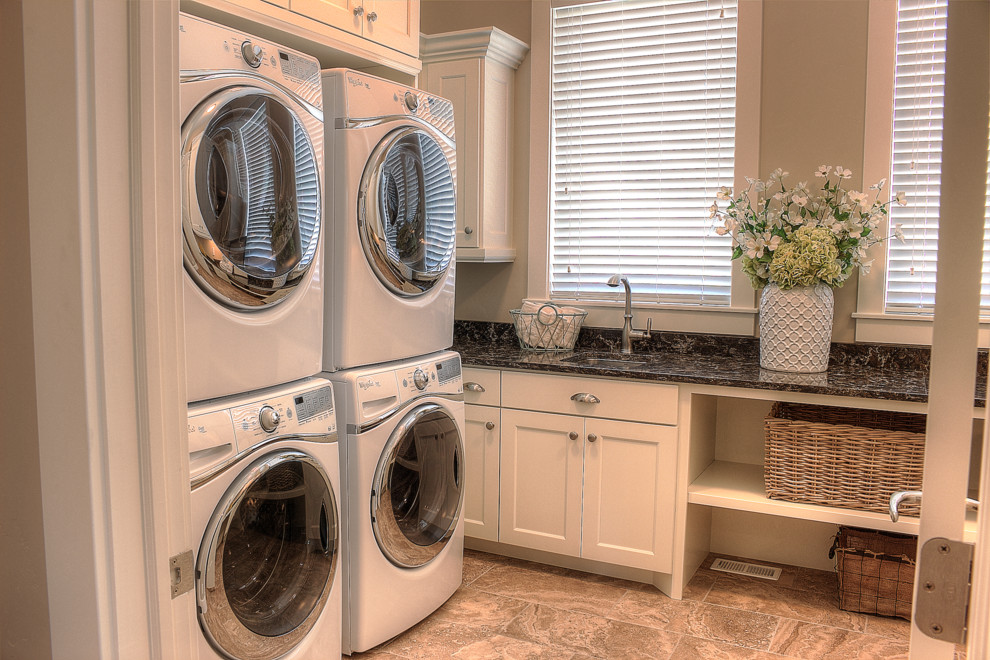 Idee per una lavanderia multiuso classica con lavello a vasca singola, ante bianche, top in marmo, pareti beige, pavimento in marmo e lavatrice e asciugatrice a colonna