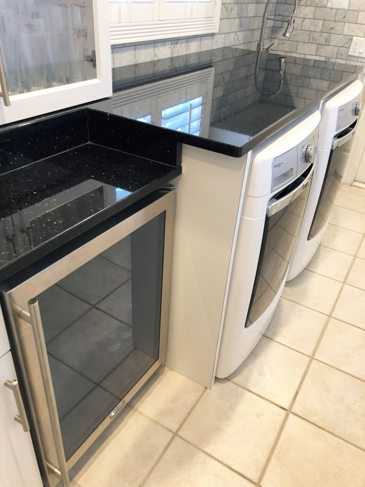 Photo of a medium sized classic galley utility room in Other with a submerged sink, shaker cabinets, white cabinets, granite worktops, white walls, ceramic flooring, a side by side washer and dryer, beige floors and black worktops.