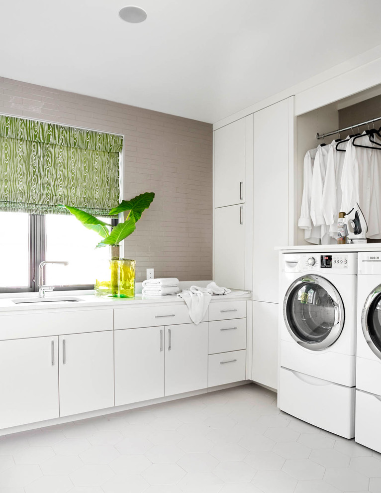 ダラスにあるコンテンポラリースタイルのおしゃれな洗濯室 (L型、アンダーカウンターシンク、フラットパネル扉のキャビネット、白いキャビネット、グレーの壁、左右配置の洗濯機・乾燥機) の写真