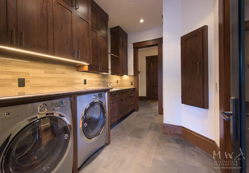 This is an example of a large traditional galley separated utility room in Other with a submerged sink, shaker cabinets, dark wood cabinets, beige walls, a side by side washer and dryer, slate flooring, grey floors and grey worktops.