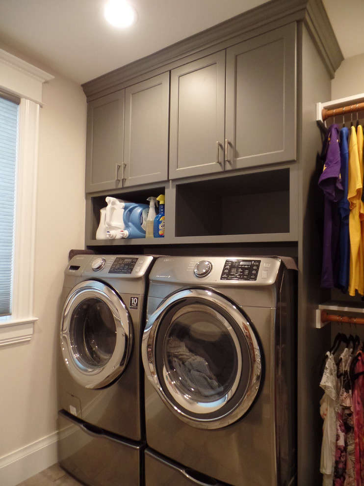 Medium sized classic utility room in Cedar Rapids with grey cabinets, laminate countertops, porcelain flooring, a side by side washer and dryer, shaker cabinets and beige walls.