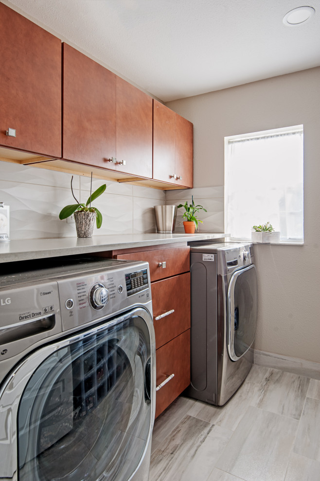 Einzeilige, Mittelgroße Moderne Waschküche mit flächenbündigen Schrankfronten, hellbraunen Holzschränken, beiger Wandfarbe, hellem Holzboden, grauem Boden und grauer Arbeitsplatte in Tampa