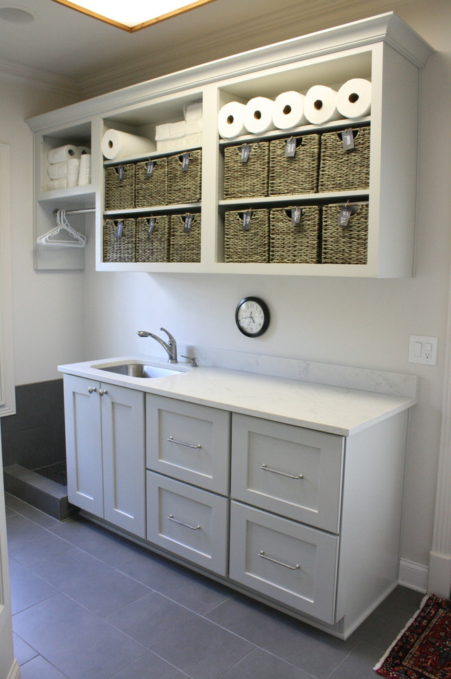 Modelo de lavadero clásico renovado con armarios con paneles empotrados, puertas de armario grises y encimera de cuarzo compacto