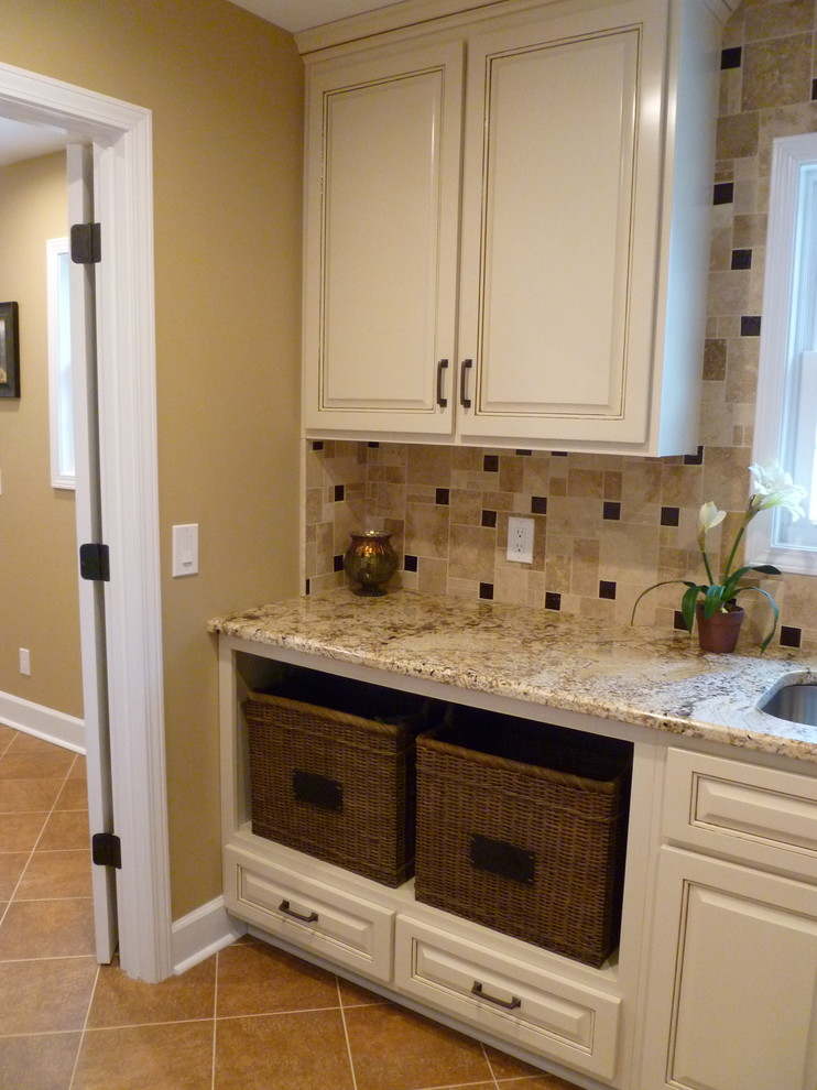 Large trendy l-shaped travertine floor dedicated laundry room photo in Nashville with an undermount sink, raised-panel cabinets, granite countertops, beige walls, a side-by-side washer/dryer and beige cabinets