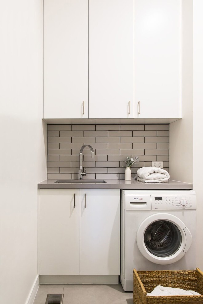 Esempio di una piccola sala lavanderia design con ante lisce, ante bianche, top in quarzo composito, lavatrice e asciugatrice affiancate e top grigio
