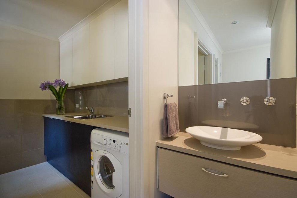 Einzeilige, Kleine Moderne Waschküche mit Waschbecken, flächenbündigen Schrankfronten, Granit-Arbeitsplatte, Keramikboden und Waschmaschine und Trockner nebeneinander in Adelaide