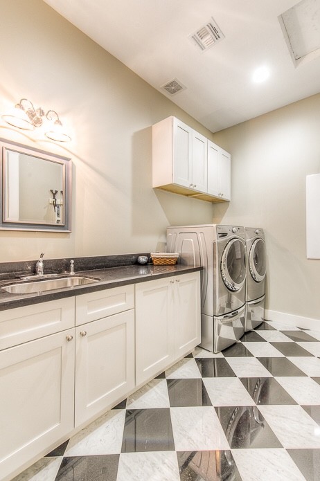 Inspiration för en mellanstor amerikansk linjär tvättstuga enbart för tvätt, med en nedsänkt diskho, skåp i shakerstil, vita skåp, bänkskiva i kvartsit, grå väggar, marmorgolv och en tvättmaskin och torktumlare bredvid varandra