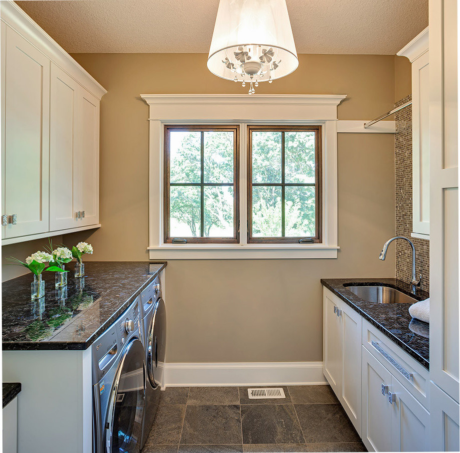 Inspiration for a mediterranean separated utility room in Minneapolis with white cabinets and a side by side washer and dryer.