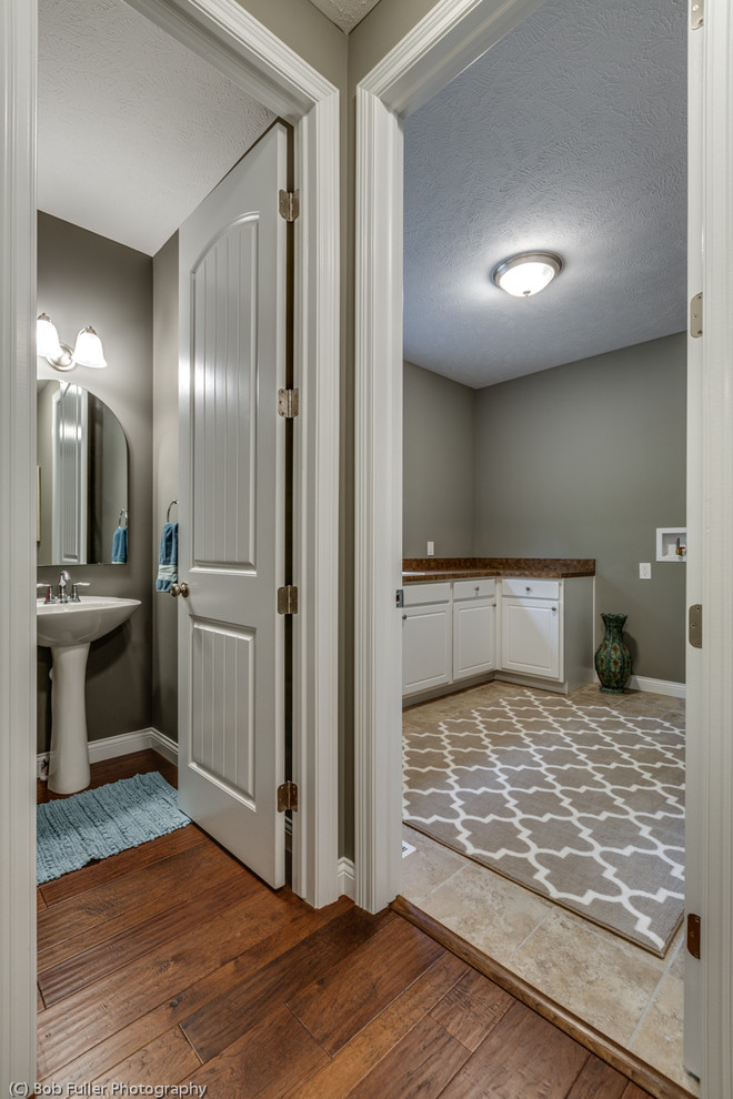 Example of a mid-sized classic ceramic tile utility room design in Cleveland with a double-bowl sink, white cabinets and laminate countertops