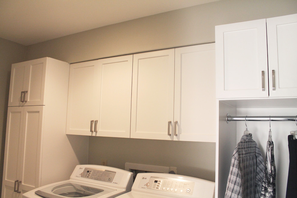 Zweizeilige, Mittelgroße Klassische Waschküche mit Schrankfronten im Shaker-Stil, weißen Schränken, grauer Wandfarbe, Porzellan-Bodenfliesen und Waschmaschine und Trockner nebeneinander in Houston