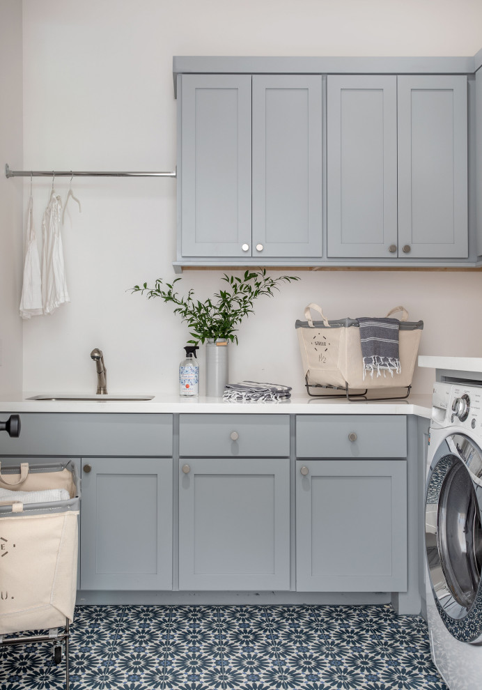 Huge transitional u-shaped ceramic tile and multicolored floor dedicated laundry room photo in Houston with a drop-in sink, gray cabinets, white walls, a side-by-side washer/dryer and white countertops