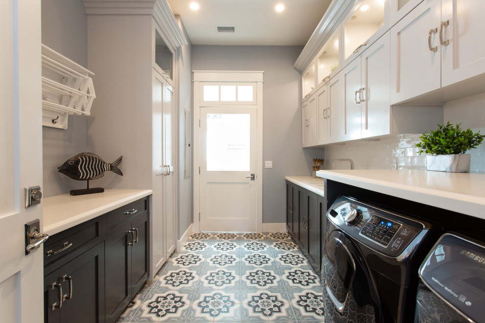 Photo of a beach style galley separated utility room in Orange County with a built-in sink, shaker cabinets, black cabinets, engineered stone countertops, white splashback, metro tiled splashback, grey walls, a side by side washer and dryer, multi-coloured floors and white worktops.