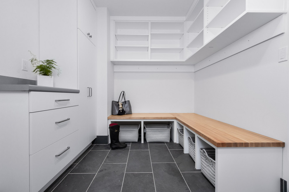 Inspiration for a mid-sized contemporary galley slate floor and gray floor dedicated laundry room remodel in Seattle with an undermount sink, flat-panel cabinets, white cabinets, laminate countertops, white walls, a side-by-side washer/dryer and gray countertops