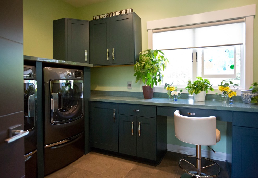 Idéer för en lantlig u-formad tvättstuga enbart för tvätt, med luckor med infälld panel, blå skåp, bänkskiva i kvarts, gröna väggar, klinkergolv i keramik, en tvättmaskin och torktumlare bredvid varandra och brunt golv