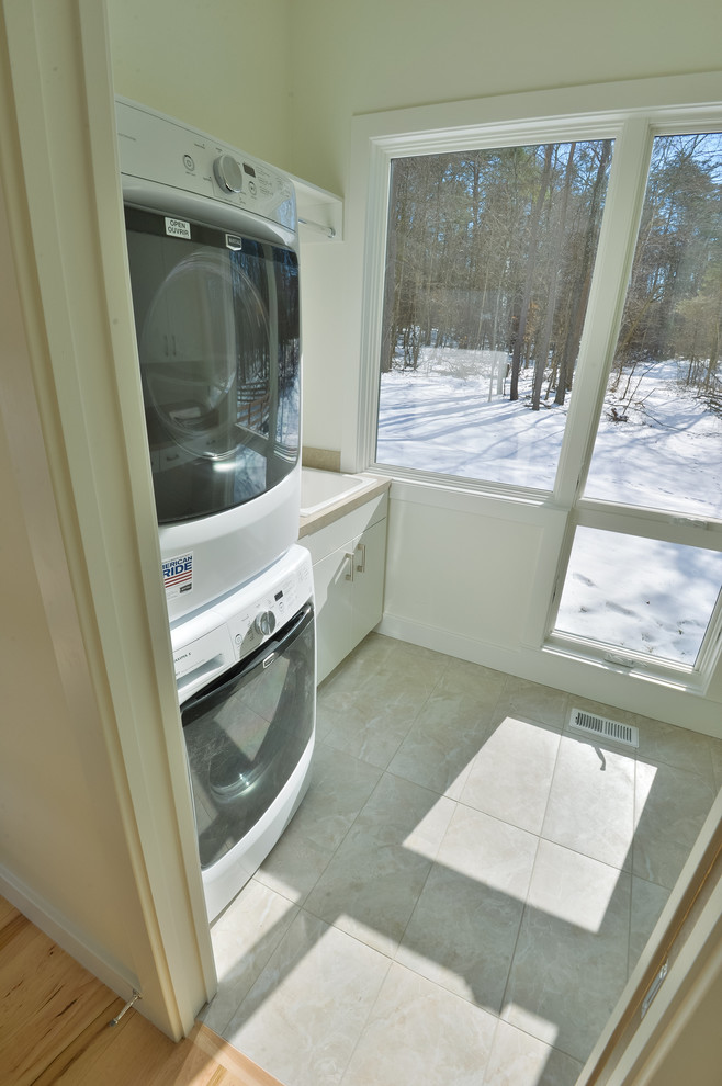 Modelo de cuarto de lavado lineal vintage con armarios con paneles lisos, puertas de armario blancas y encimera de acrílico