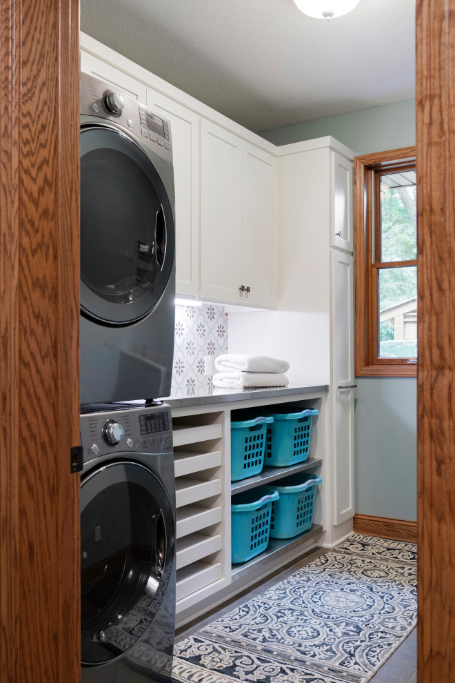 Moderner Hauswirtschaftsraum mit Schrankfronten im Shaker-Stil, weißen Schränken, Porzellan-Bodenfliesen und Waschmaschine und Trockner gestapelt in Minneapolis