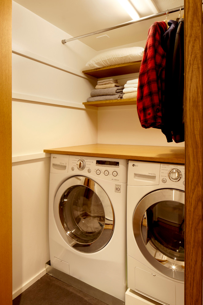 Laundry closet - 1960s laundry closet idea in Seattle with a side-by-side washer/dryer