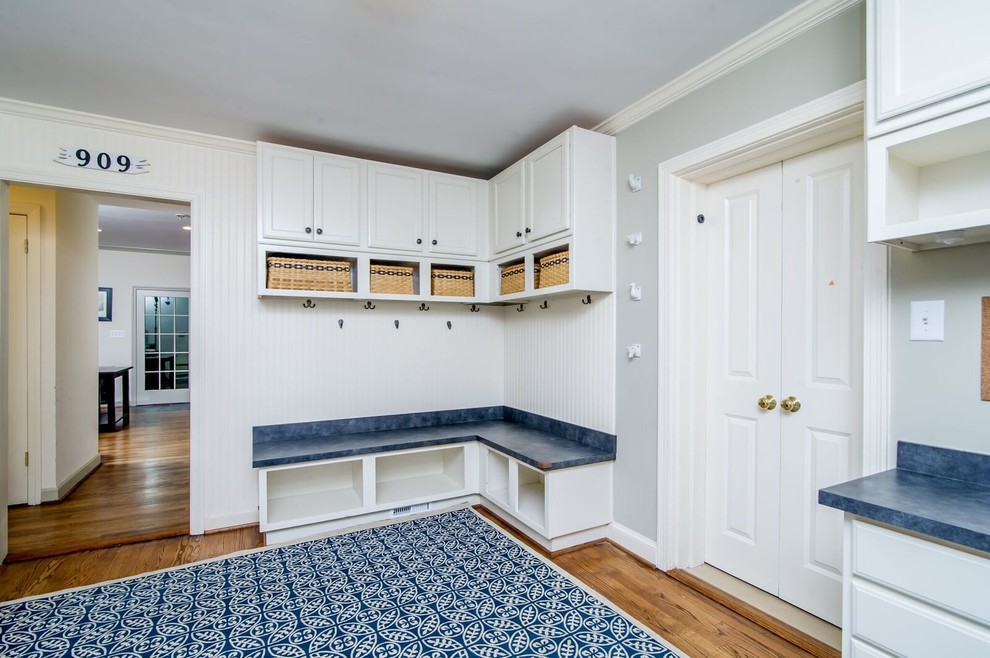 Inspiration for a large midcentury utility room in Baltimore with recessed-panel cabinets, white cabinets, laminate countertops, white walls and medium hardwood flooring.