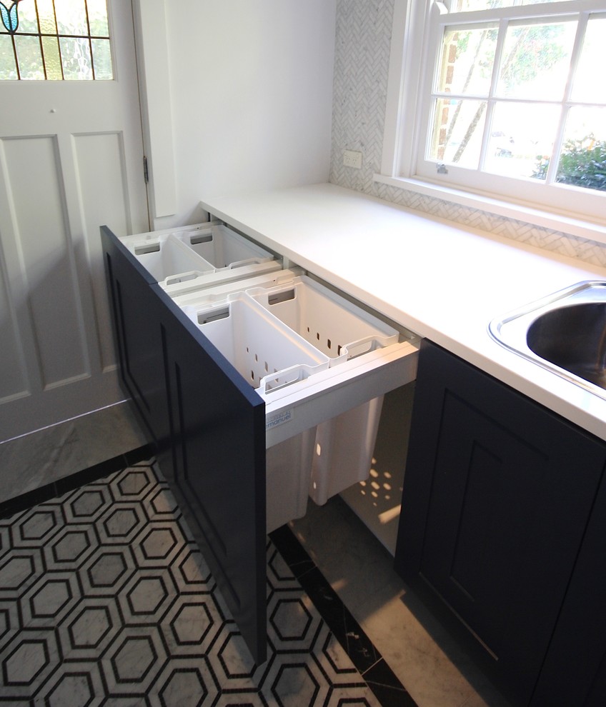 Foto på en mellanstor funkis vita linjär tvättstuga enbart för tvätt, med en nedsänkt diskho, luckor med infälld panel, svarta skåp, bänkskiva i kvarts, vita väggar, marmorgolv, en tvättpelare och grått golv