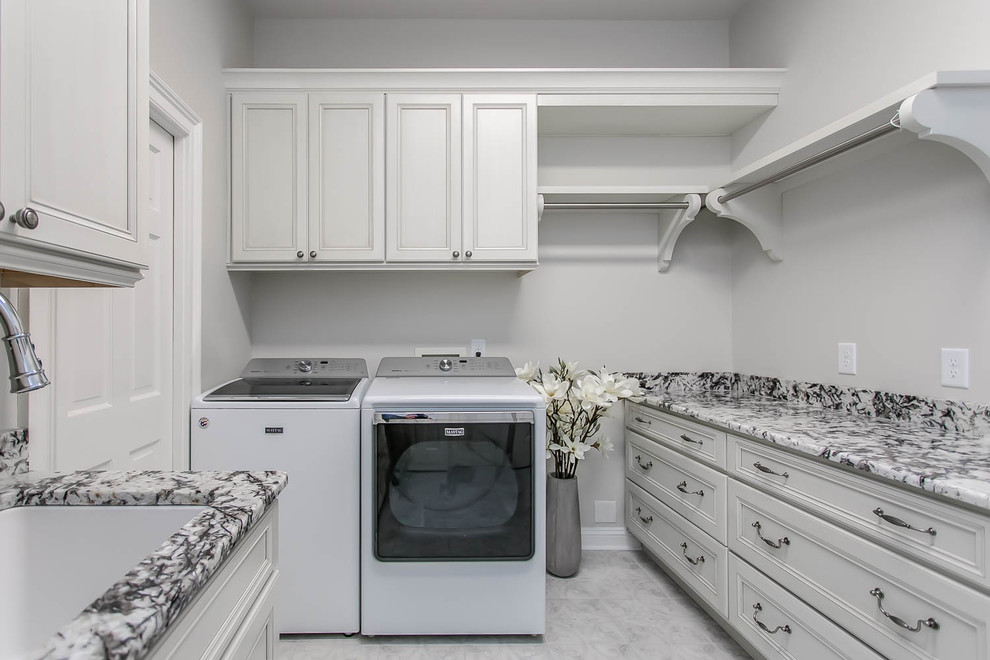 Foto di una lavanderia classica con lavello sottopiano, ante lisce, ante bianche, top in quarzo composito, pavimento in marmo, pavimento marrone e top bianco